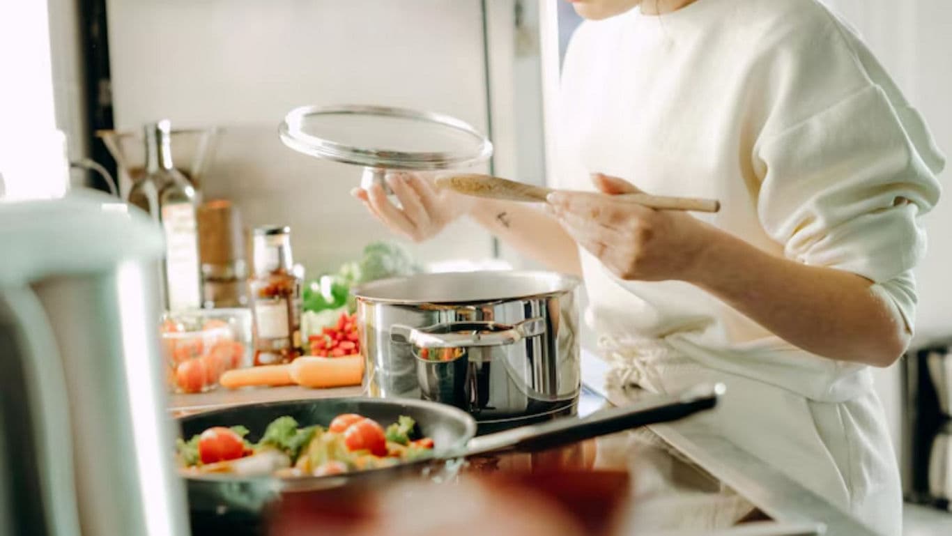 Woman cooking with fresh vegetables in kitchen