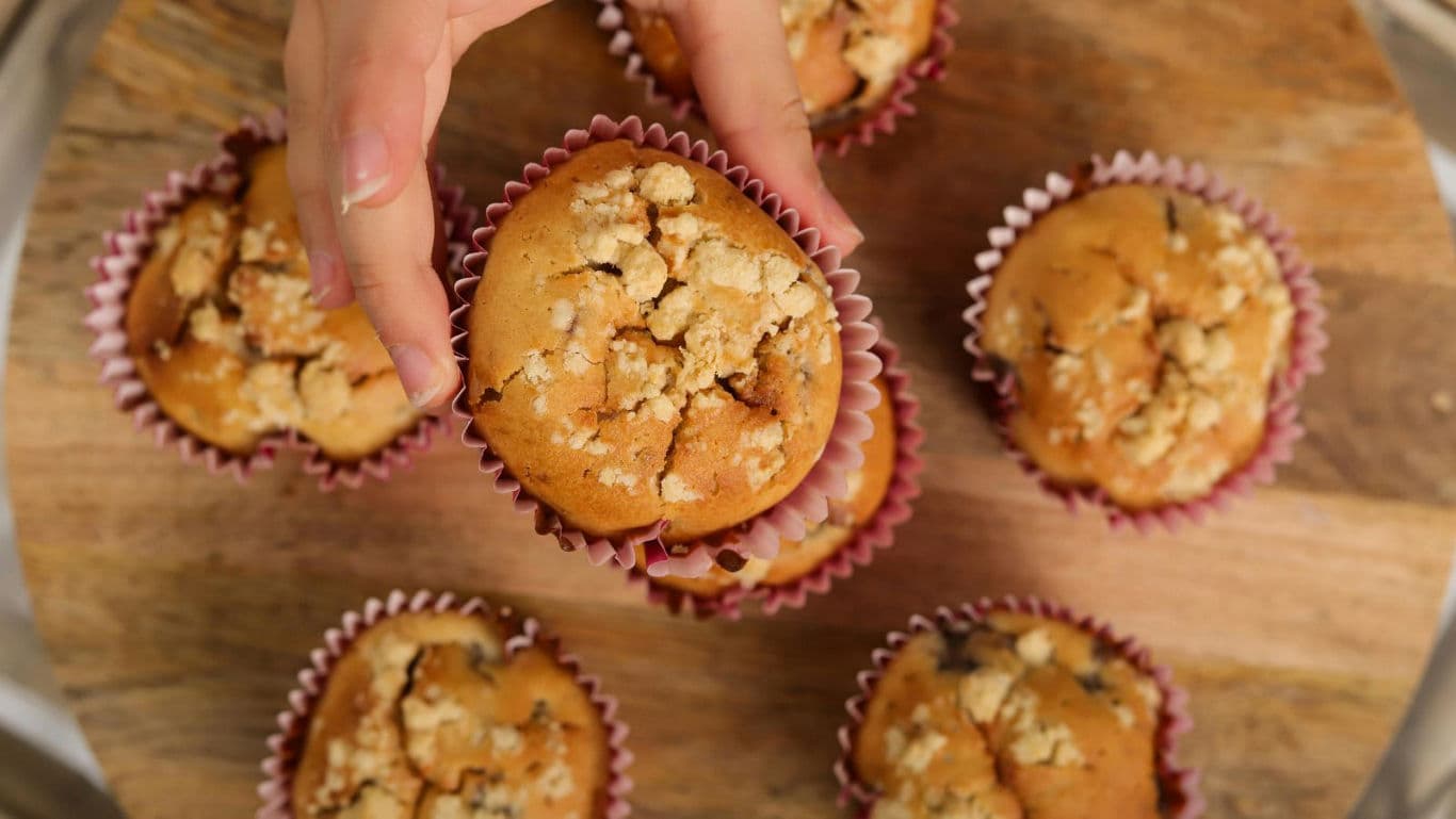 Hand Picking Fresh Crumb Topped Muffin