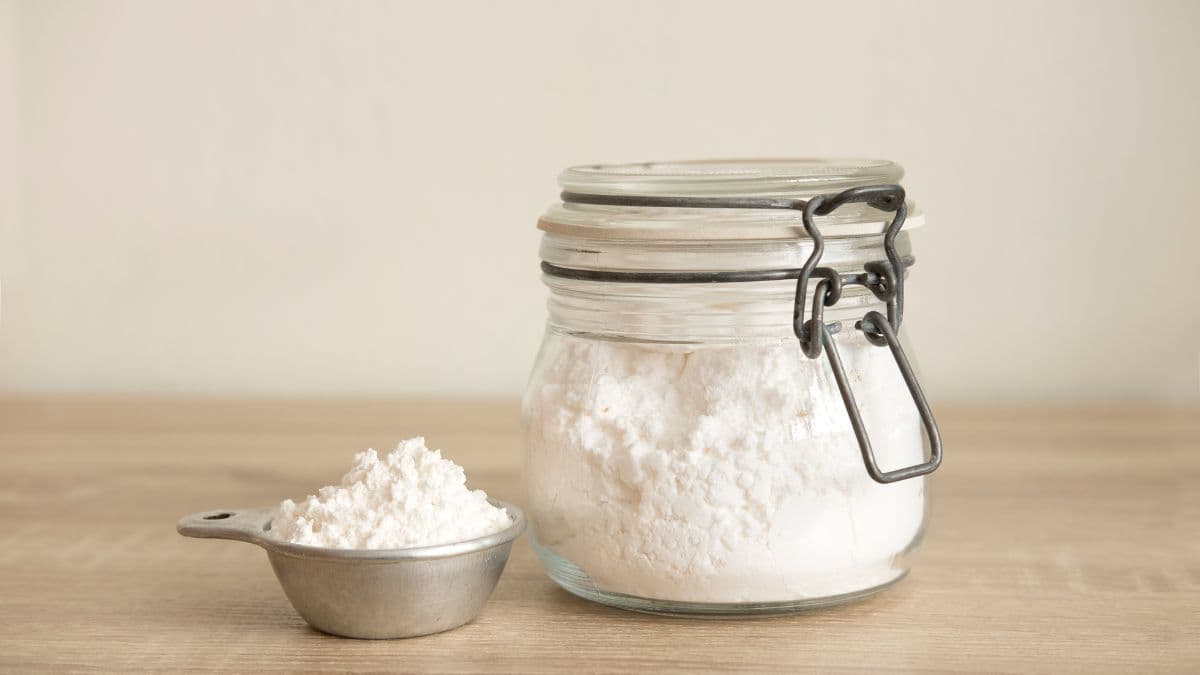 A jar of flour with a scooper