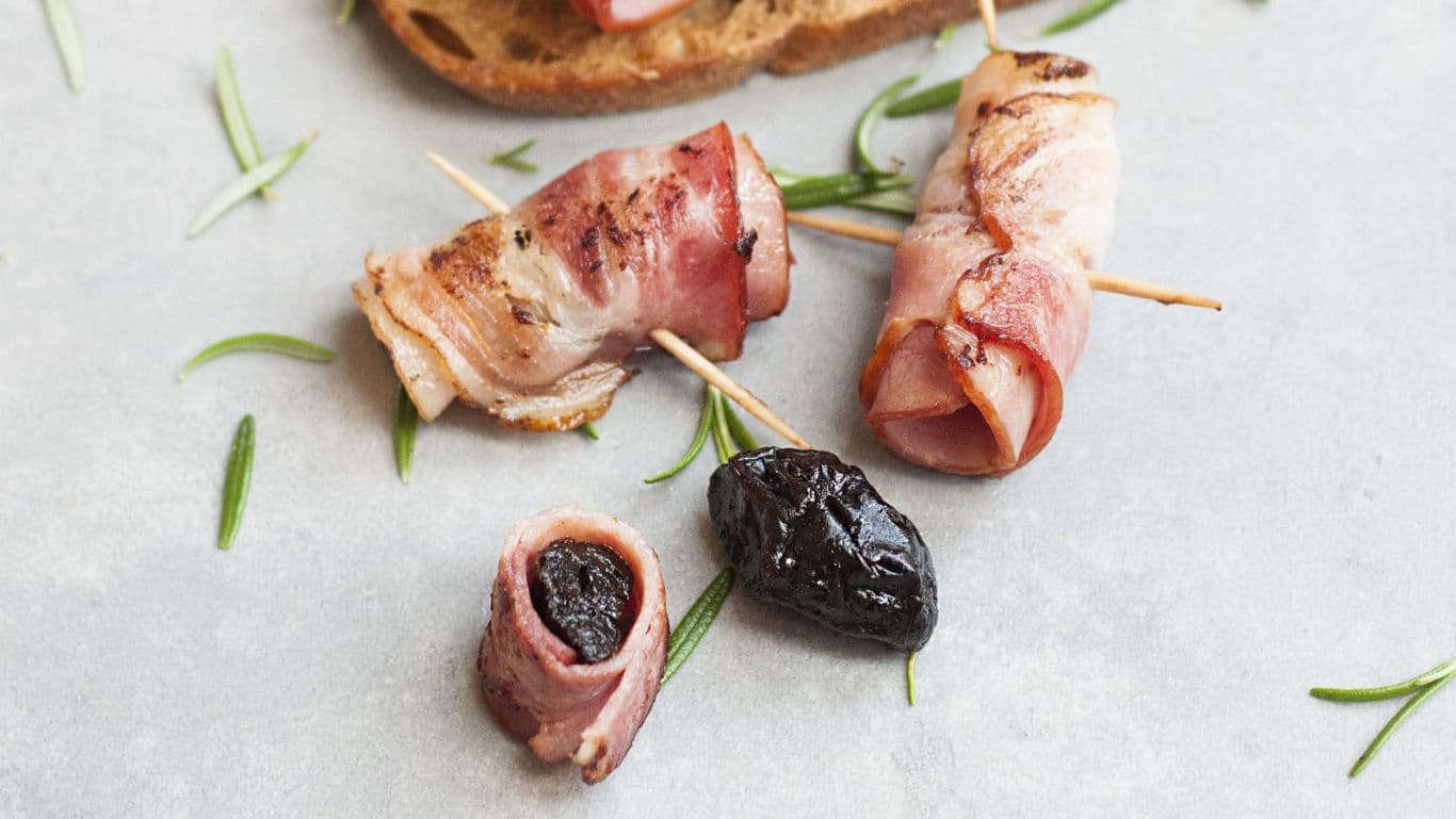 Bacon wrapped prunes appetizer with rosemary