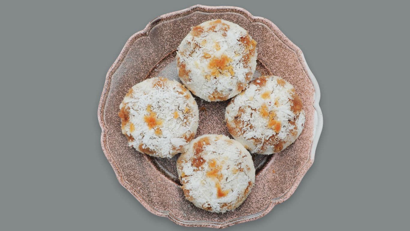 Four coconut-topped cookies on vintage plate