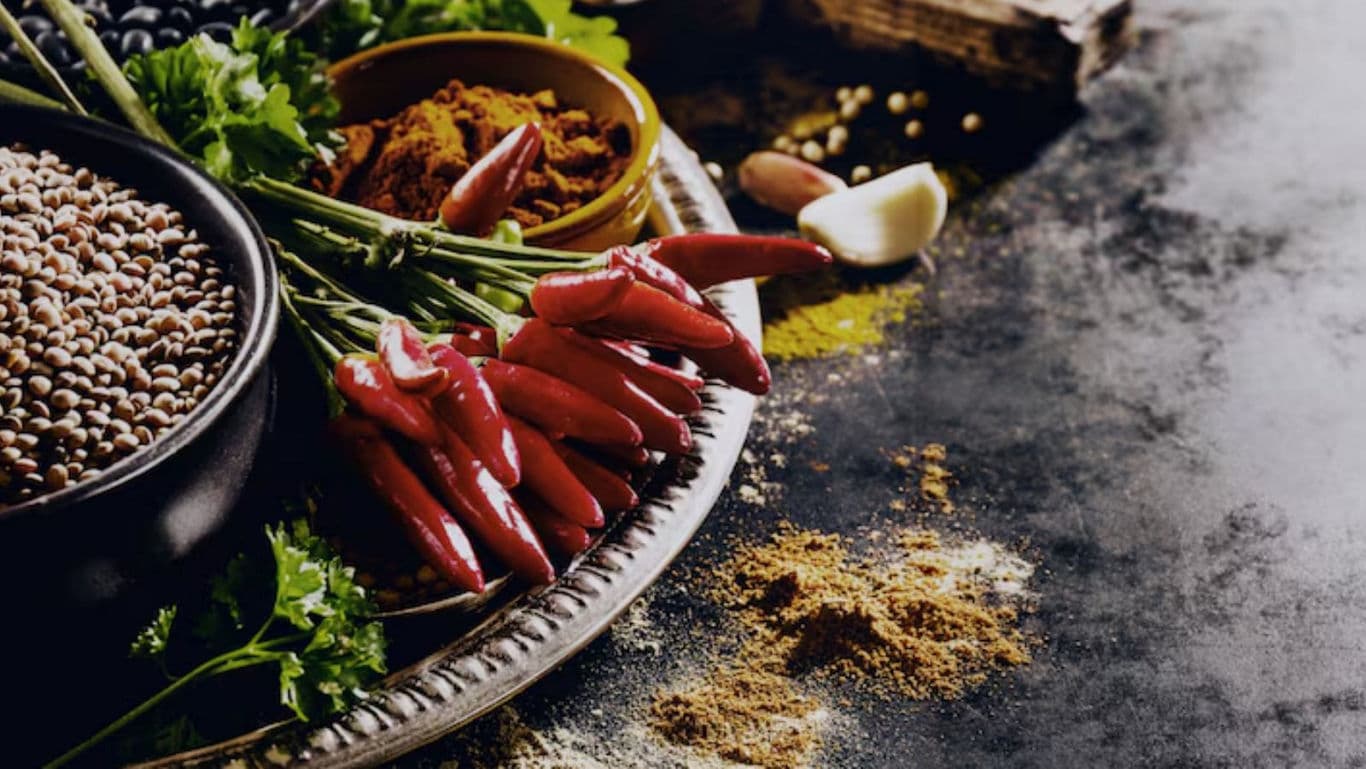 Assorted Spices and Fresh Red Chilies on Rustic Table