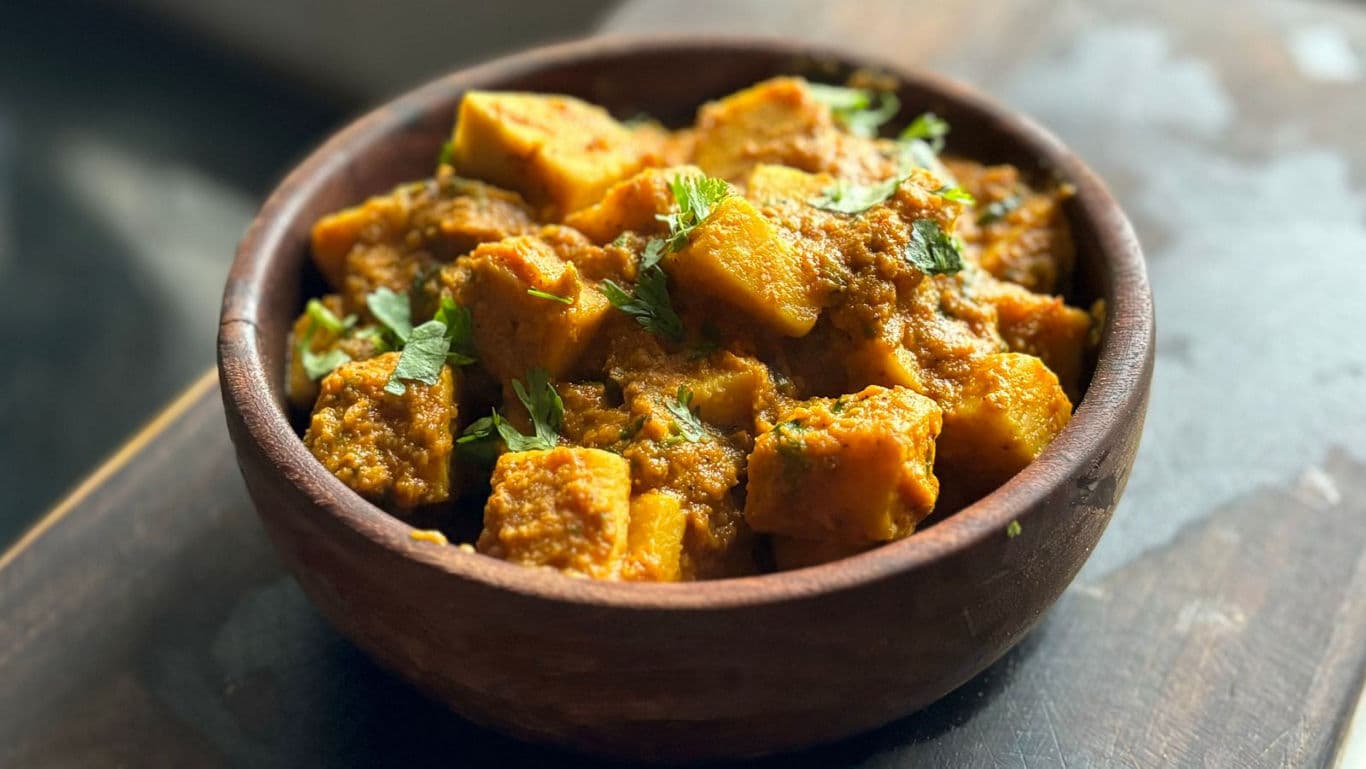 Spiced potato curry in wooden bowl