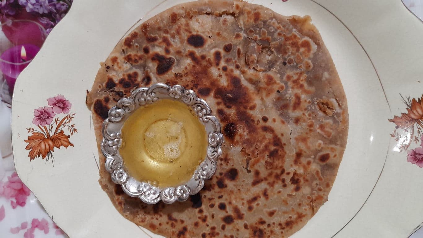 Traditional Indian flatbread with ghee on floral plate