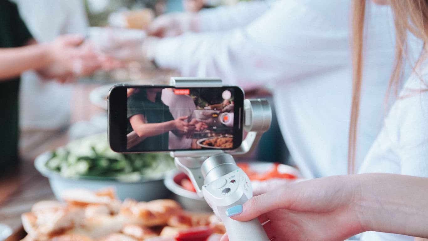 Smartphone filming food preparation at gathering