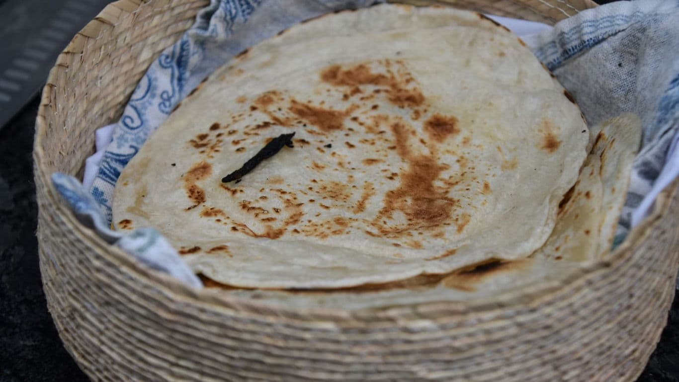 Freshly made flatbread in woven basket close-up