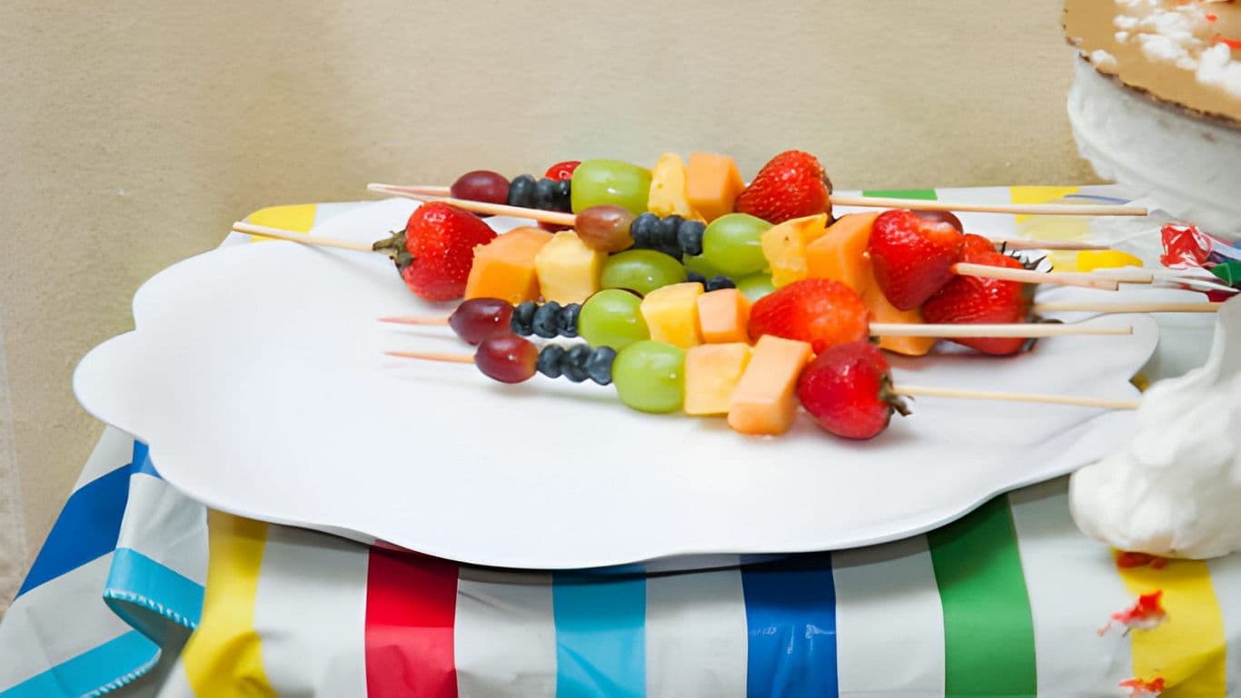 Colorful fruit skewers on festive table