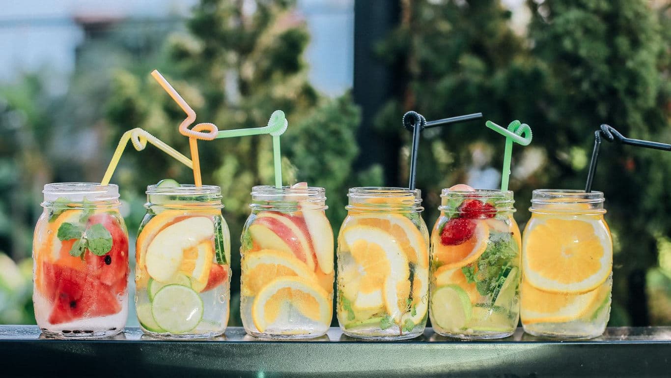 Colorful Fruit Infused Water in Mason Jars Outdoors