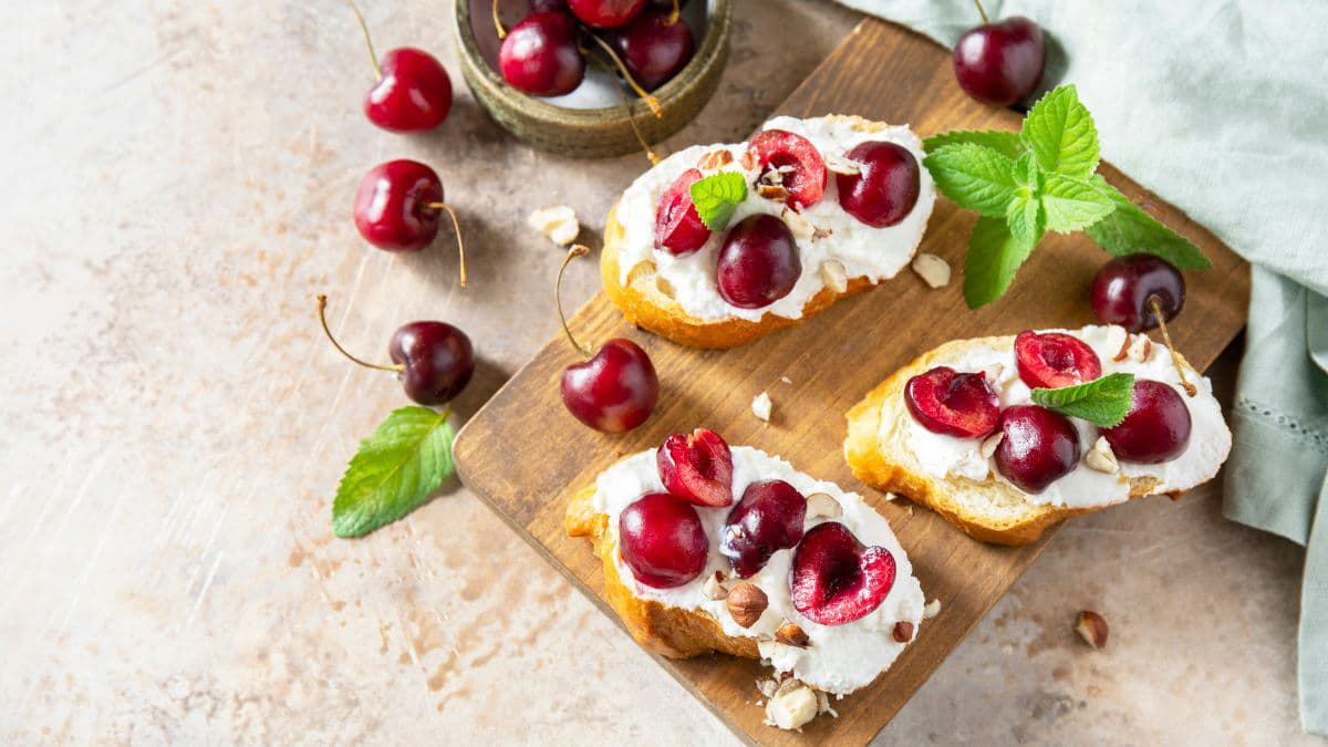Roasted cherry on toasts on a wooden tray