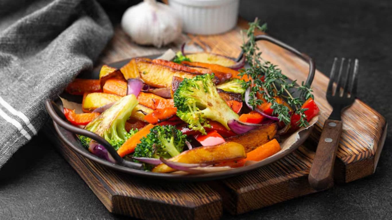 Colorful roasted vegetables on wooden board