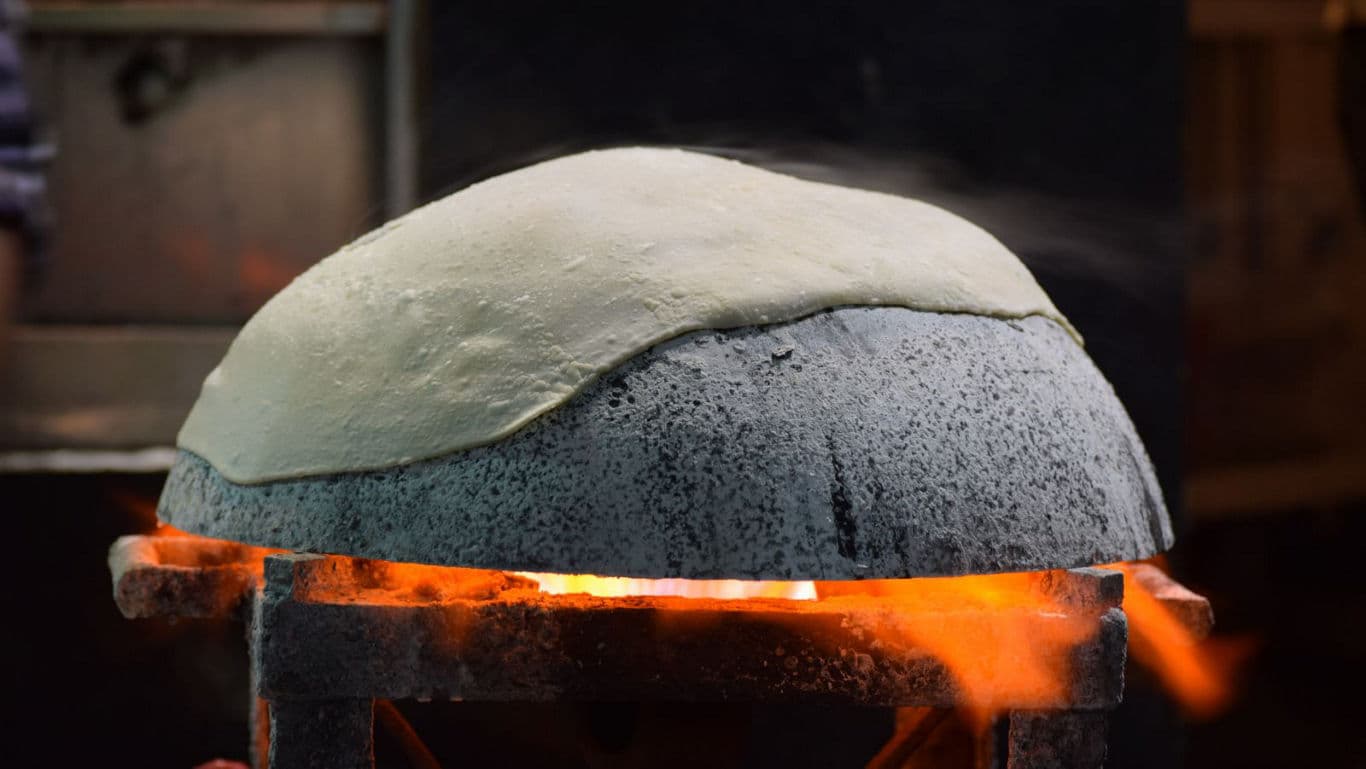 Flatbread dough baking over open flame