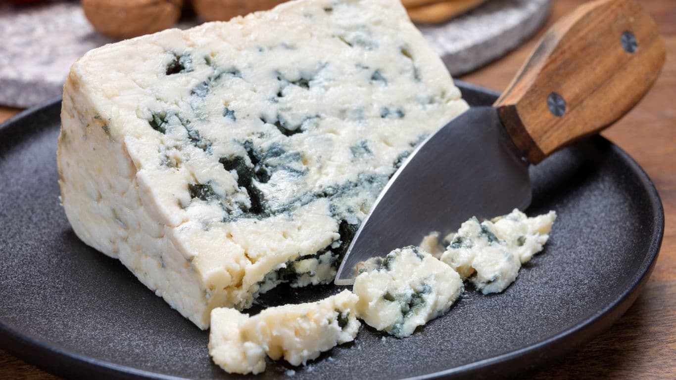 Blue cheese wedge on rustic serving plate