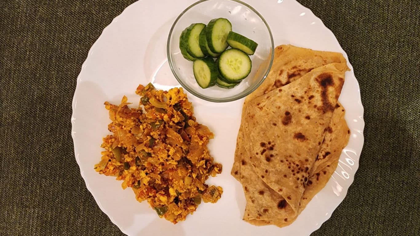 Indian vegetarian meal with chapati, sabzi, and cucumber