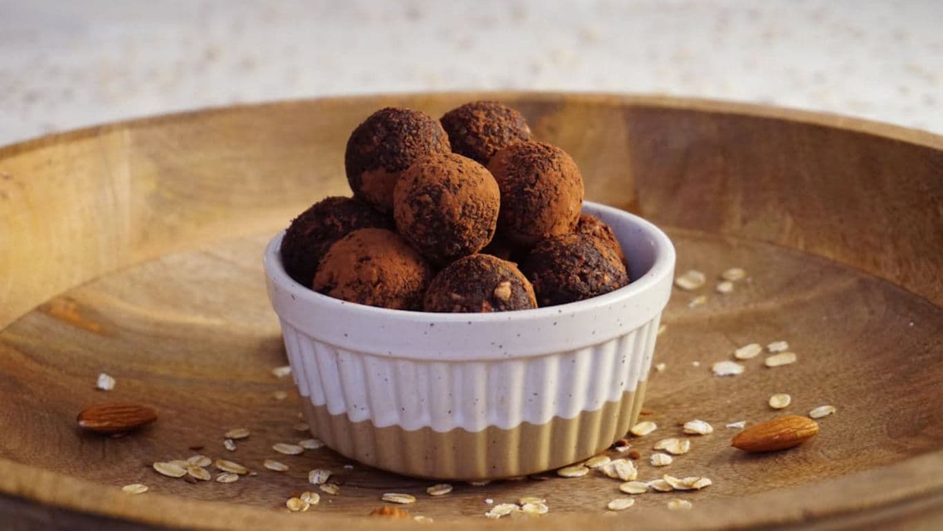 Chocolate truffles in ceramic bowl on wooden tray