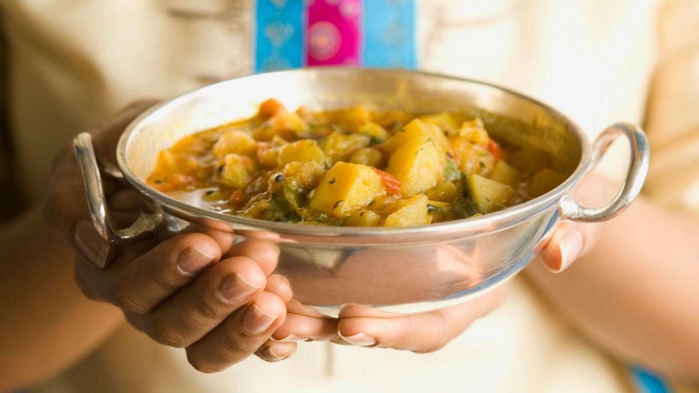 Traditional Indian curry served in metal bowl