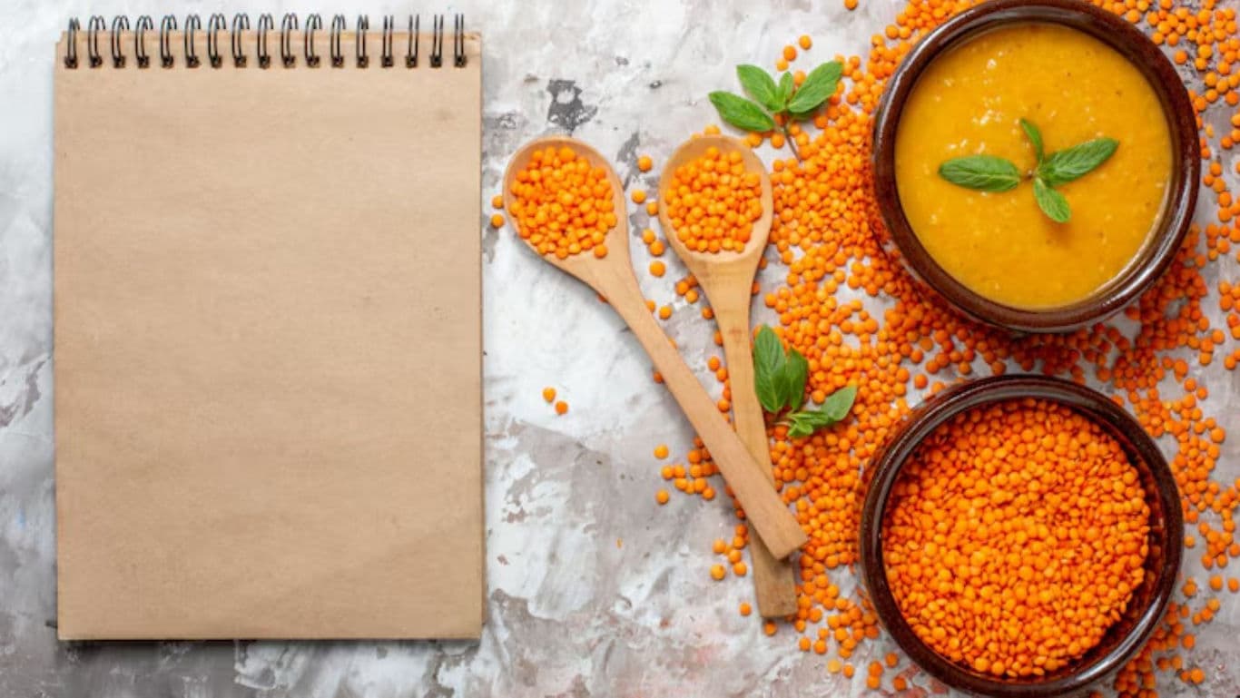 Notebook with lentils and soup on table