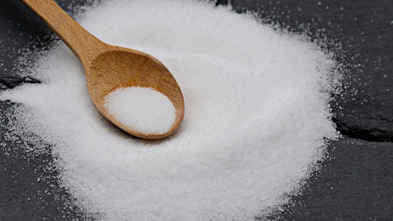 Wooden Spoon with White Granulated Substance on Slate