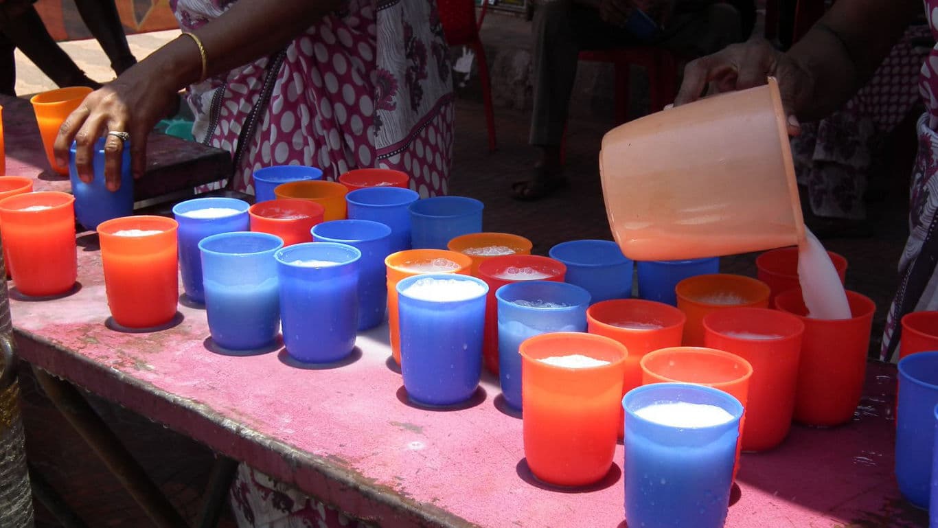 Colorful Plastic Cups Filled With Milk Outdoors