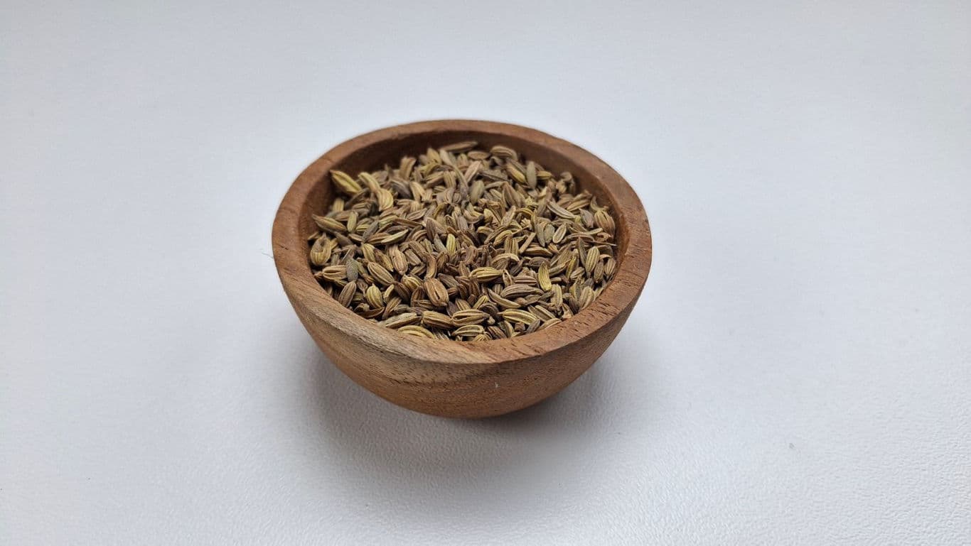 Wooden bowl filled with dried cumin seeds