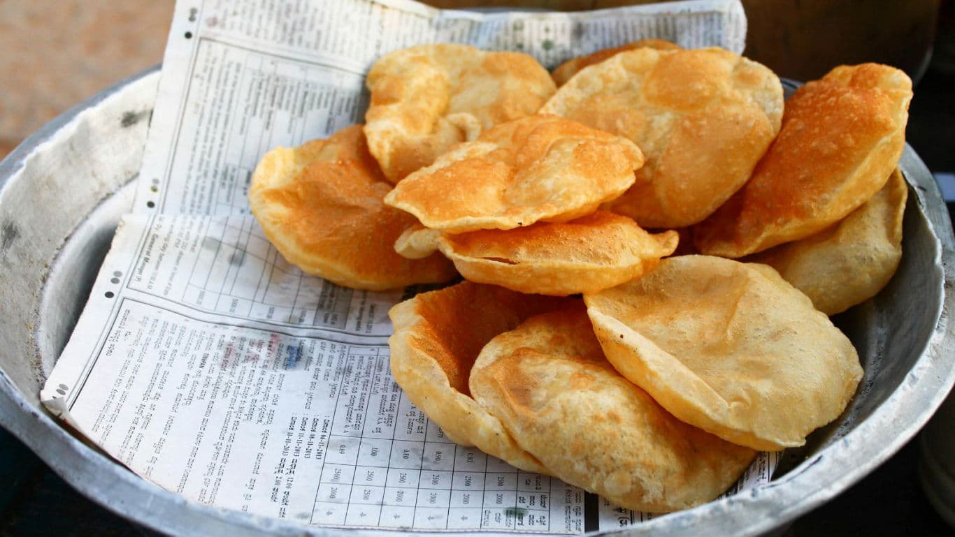 Freshly fried Indian puri bread on paper