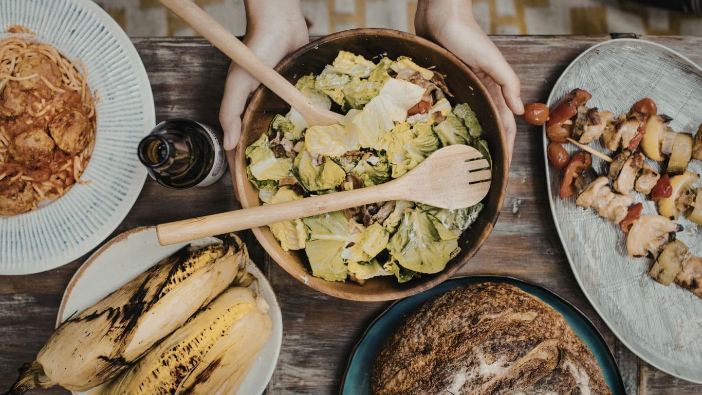 Rustic shared meal with salad and skewers