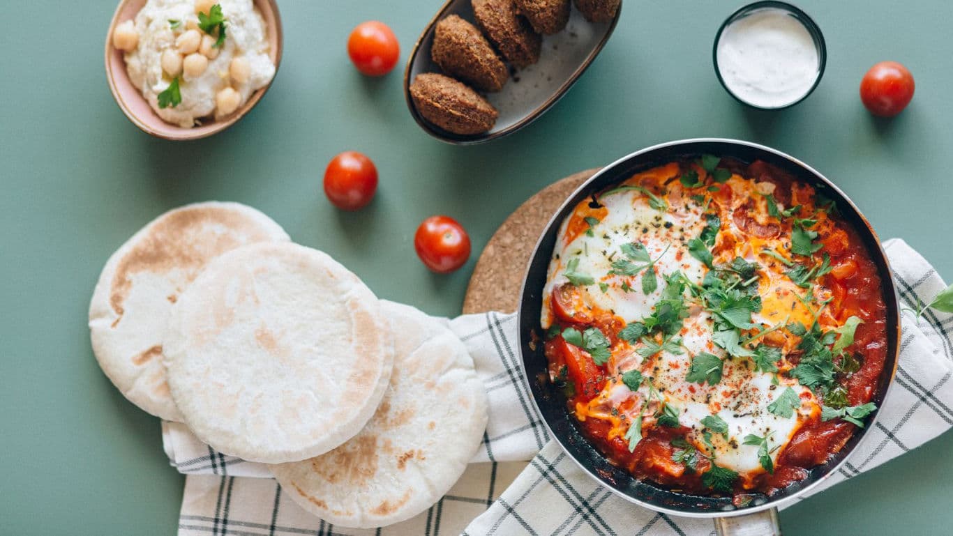 Shakshouka with bread and condiments