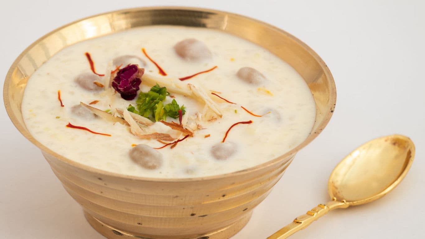 Traditional Indian dessert in golden bowl with garnish