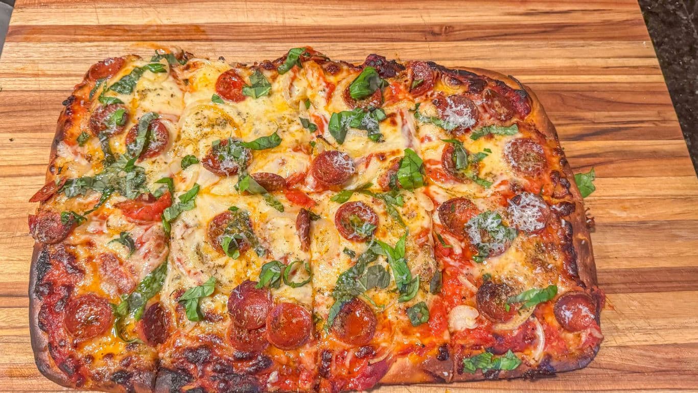 Homemade rectangular pepperoni pizza on board