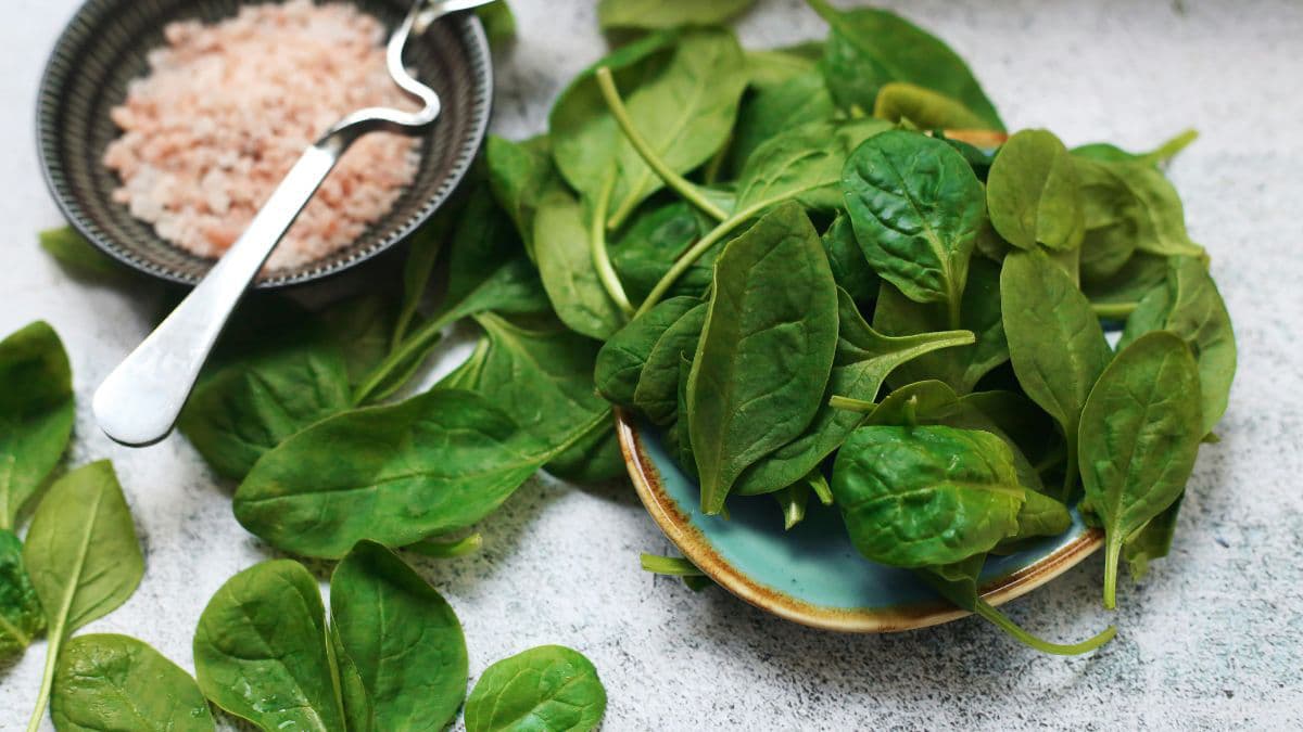 Plate of spinach beside a bowl of rice