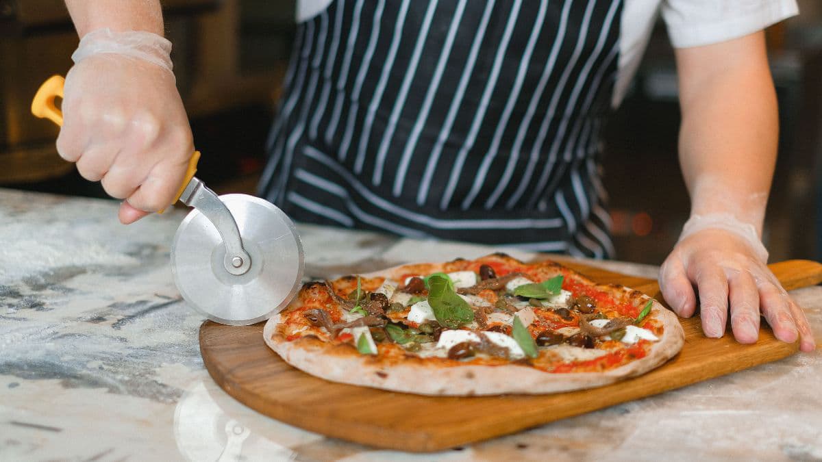 Cutting a freshly baked homemade pizza