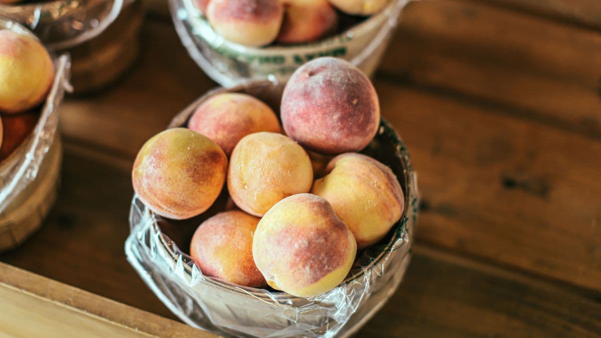 Ripe peaches displayed in wooden baskets 