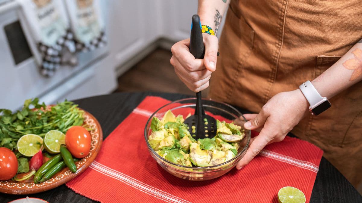Mashing avocado for chunky guacamole texture 