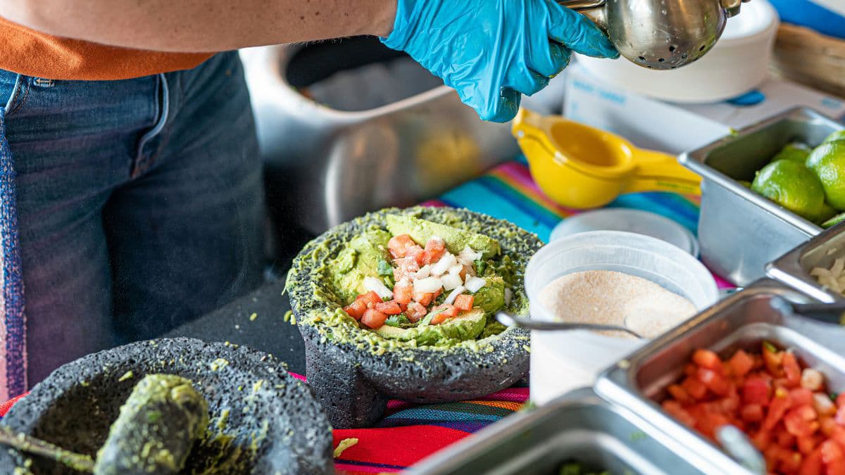 Adding lime and onion to mashed avocado