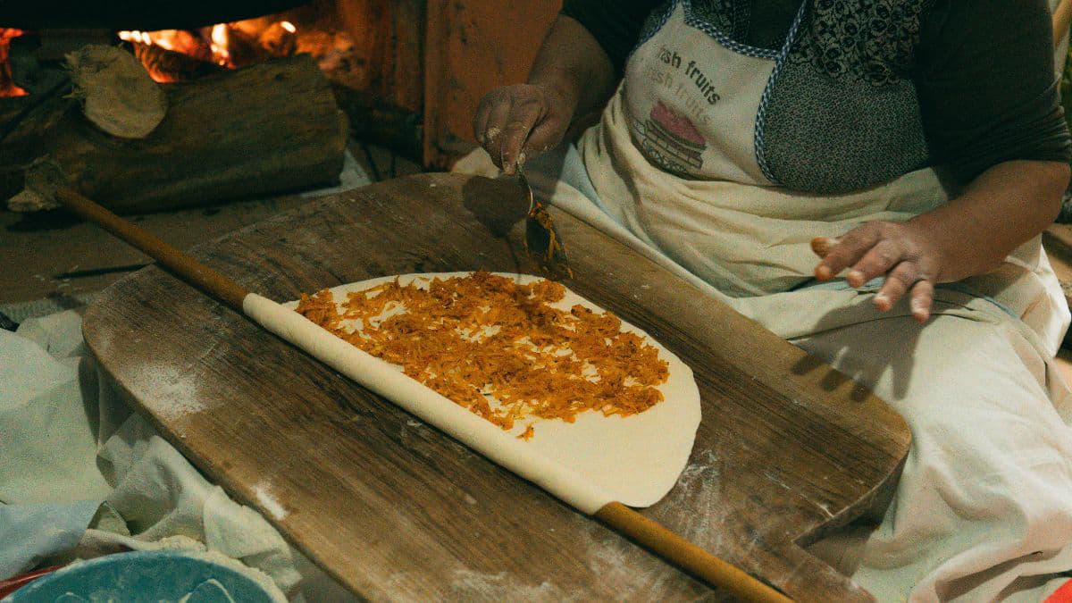 Adding cinnamon sugar filling to rolled dough 