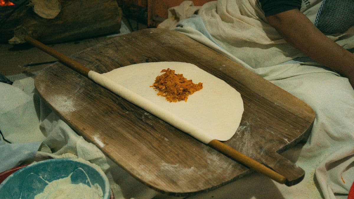 Rolling out thin traditional sweet boli dough 