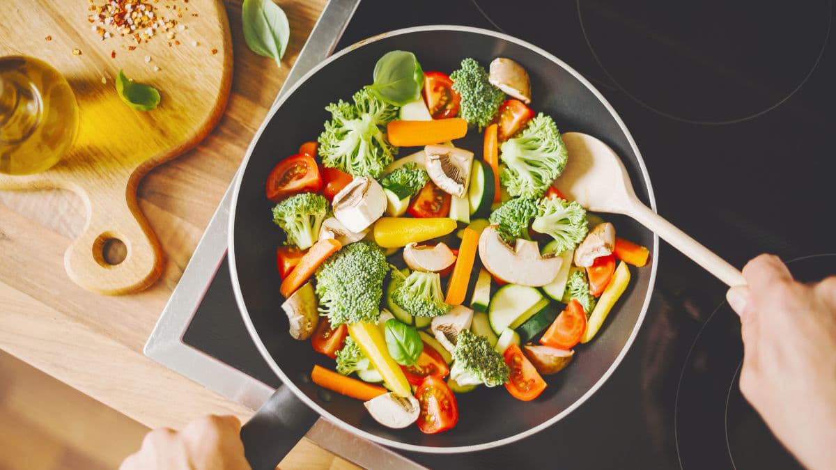 A person stir-frying the vegetables