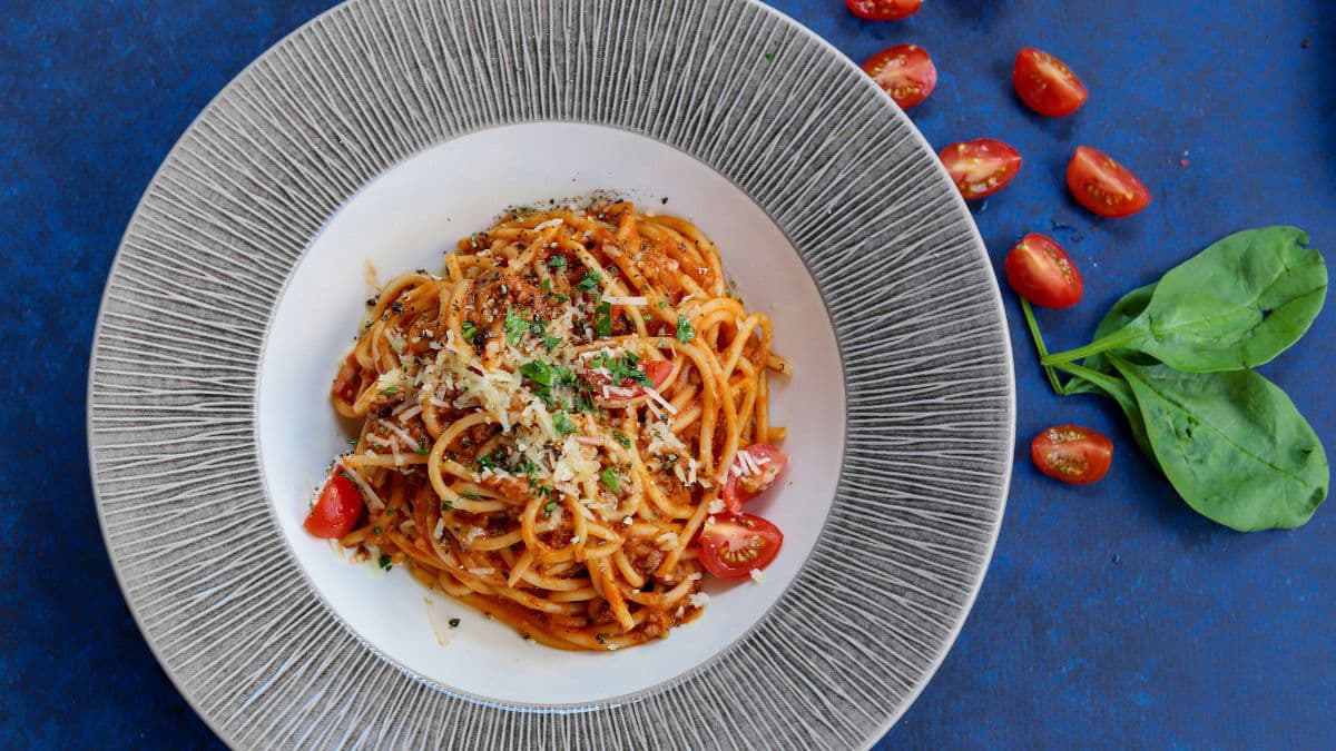 Red sauce pasta on a ceramic plate