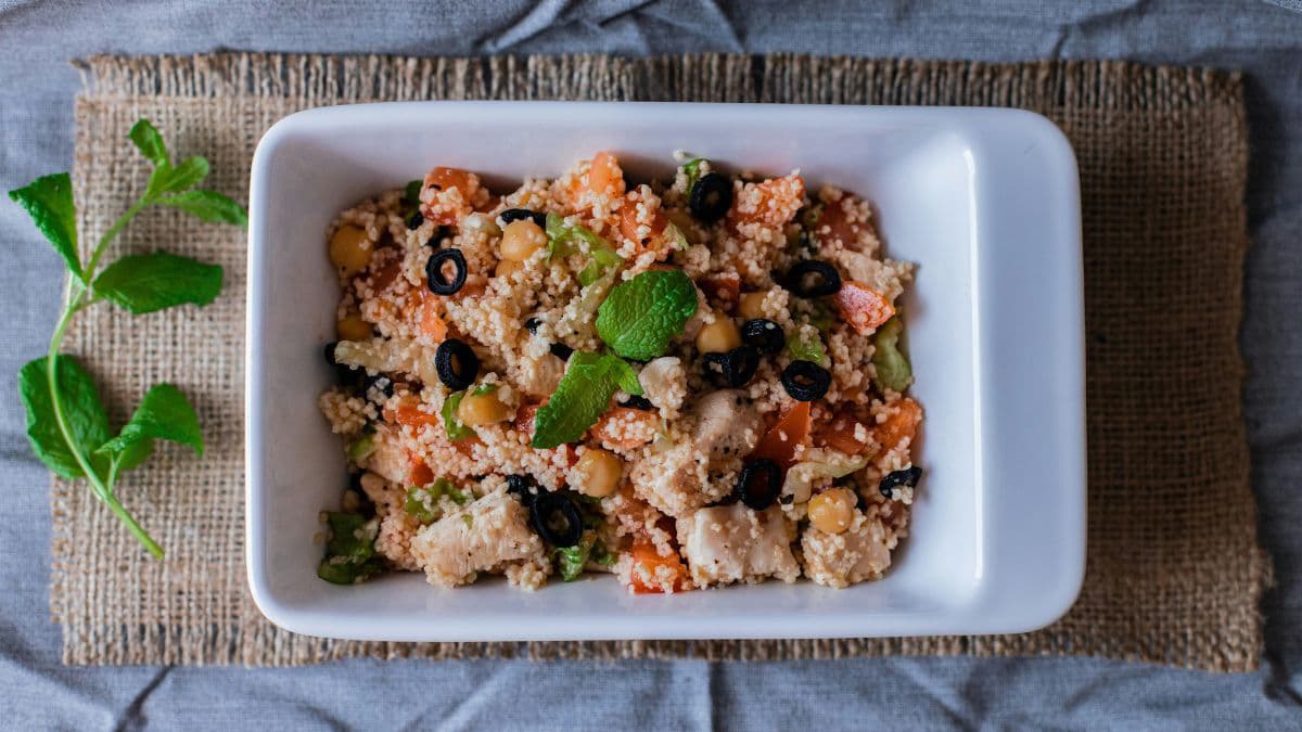 Fresh grain and vegetable salad served in a container