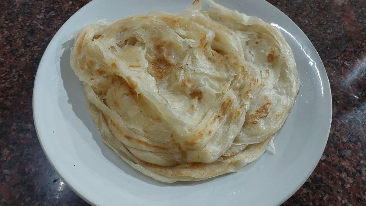 Soft parotta on a white plate