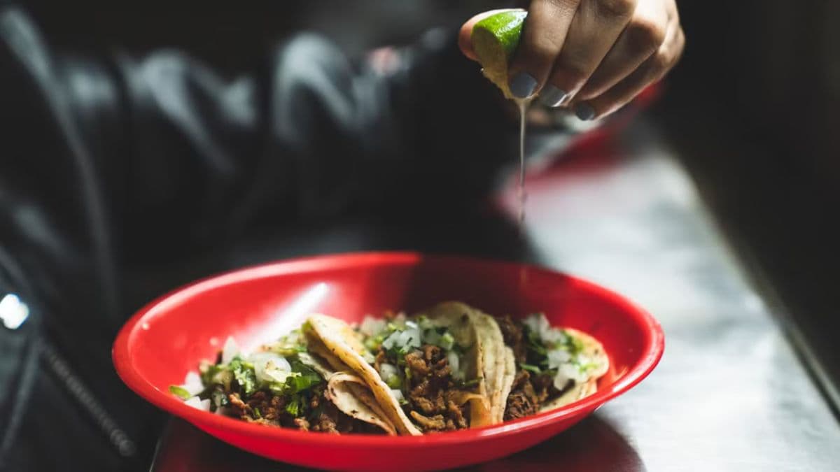 person squeezing lime on tacos