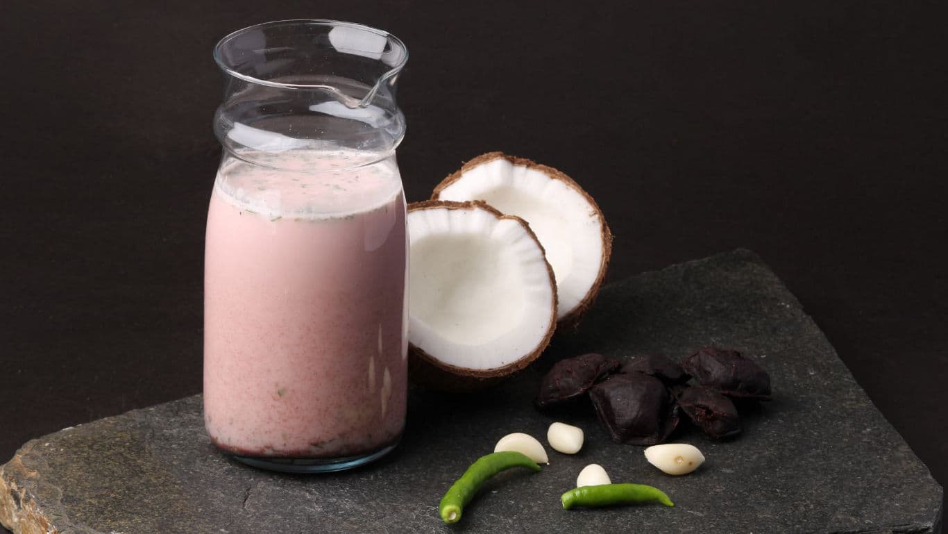 Pink coconut beverage with spices on slate