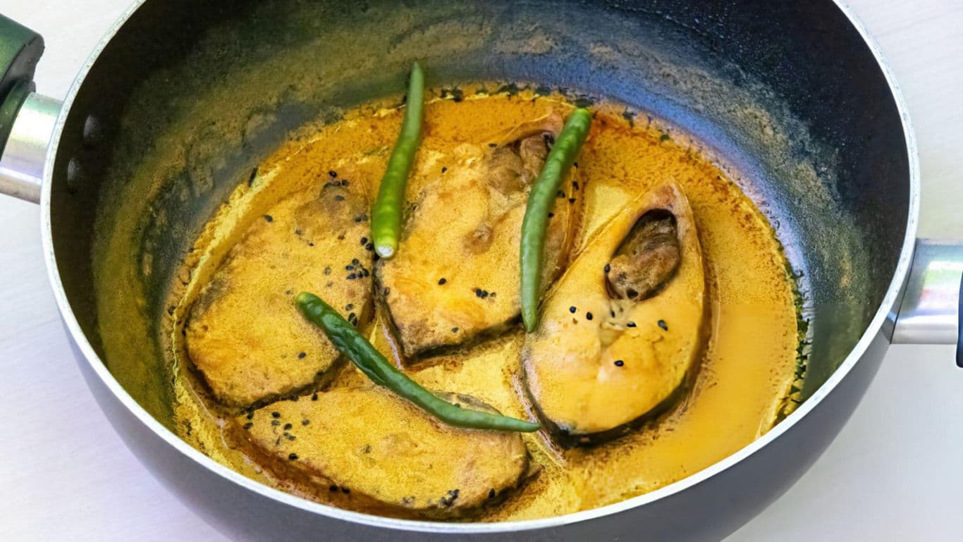 Fish curry with green chilies in black pan