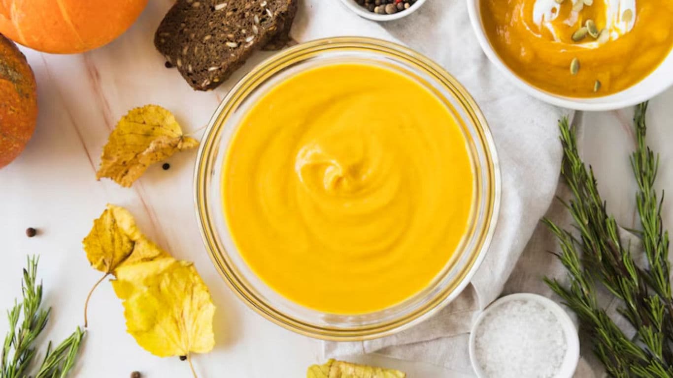 Creamy pumpkin soup with autumn herbs and bread