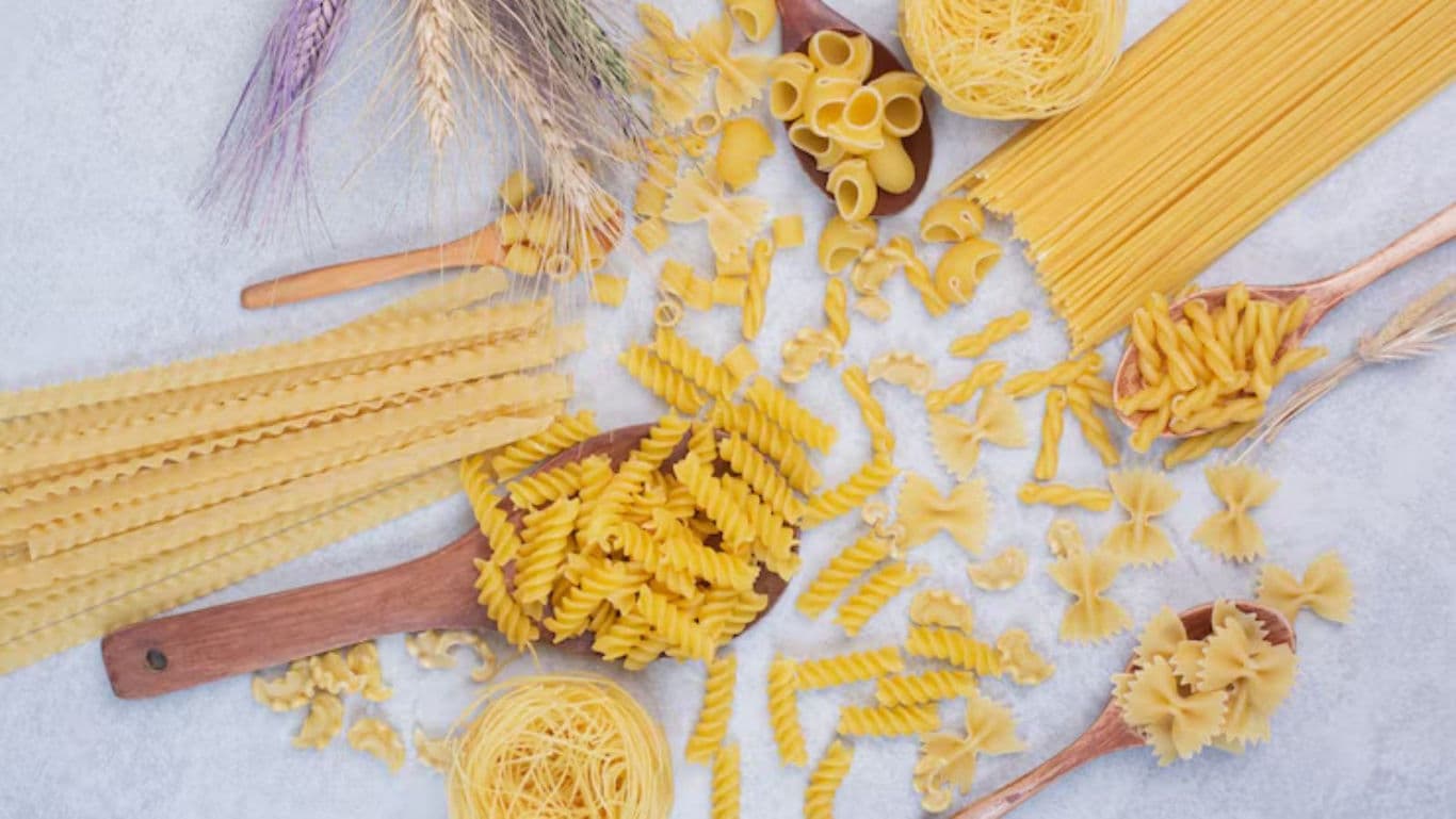 Assorted Uncooked Pasta Varieties on White Surface