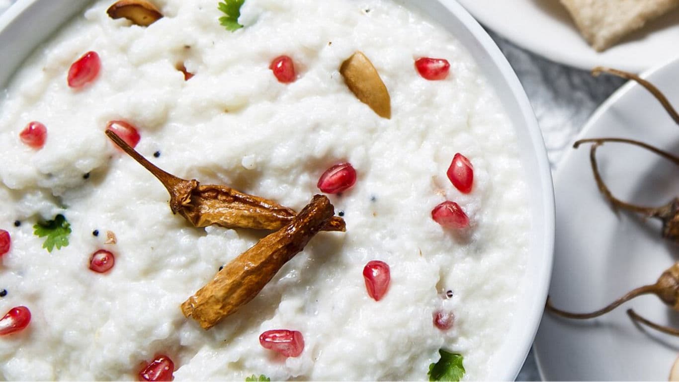 Curd rice garnished with pomegranate and chilies