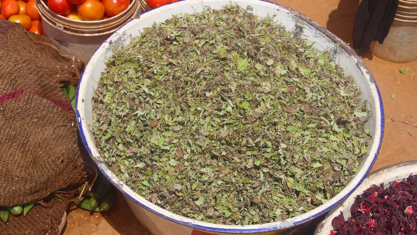 Large basin of dried green herbs at market