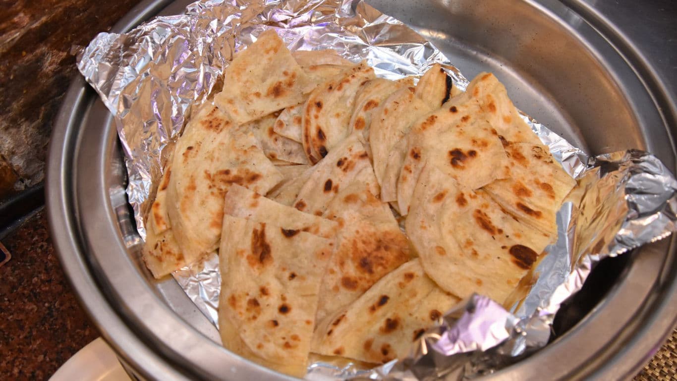 Freshly cooked flatbread slices in metal tray