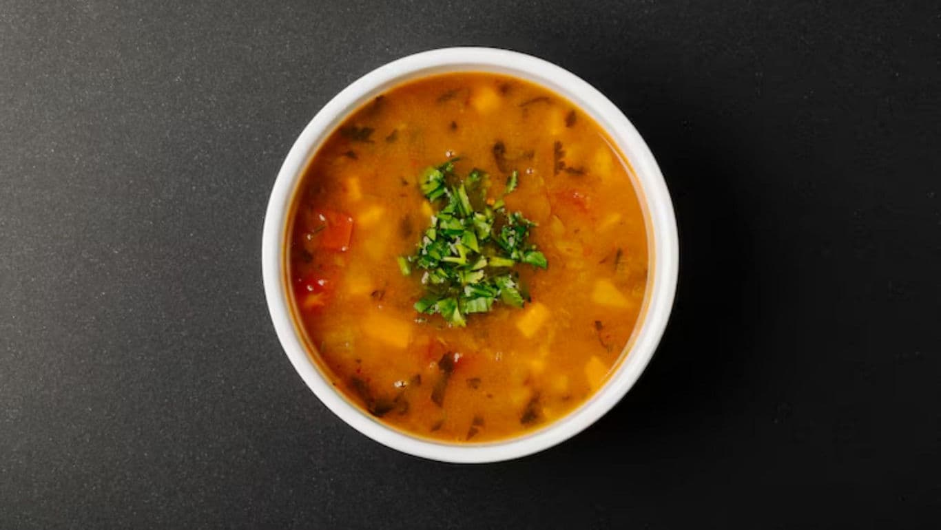 Bowl of vegetable soup with fresh herbs garnish