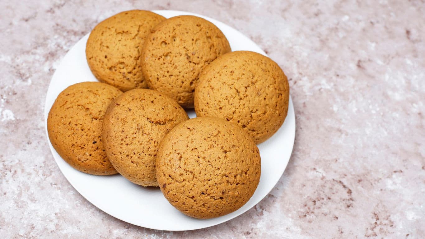 Plate of round golden cookies on table