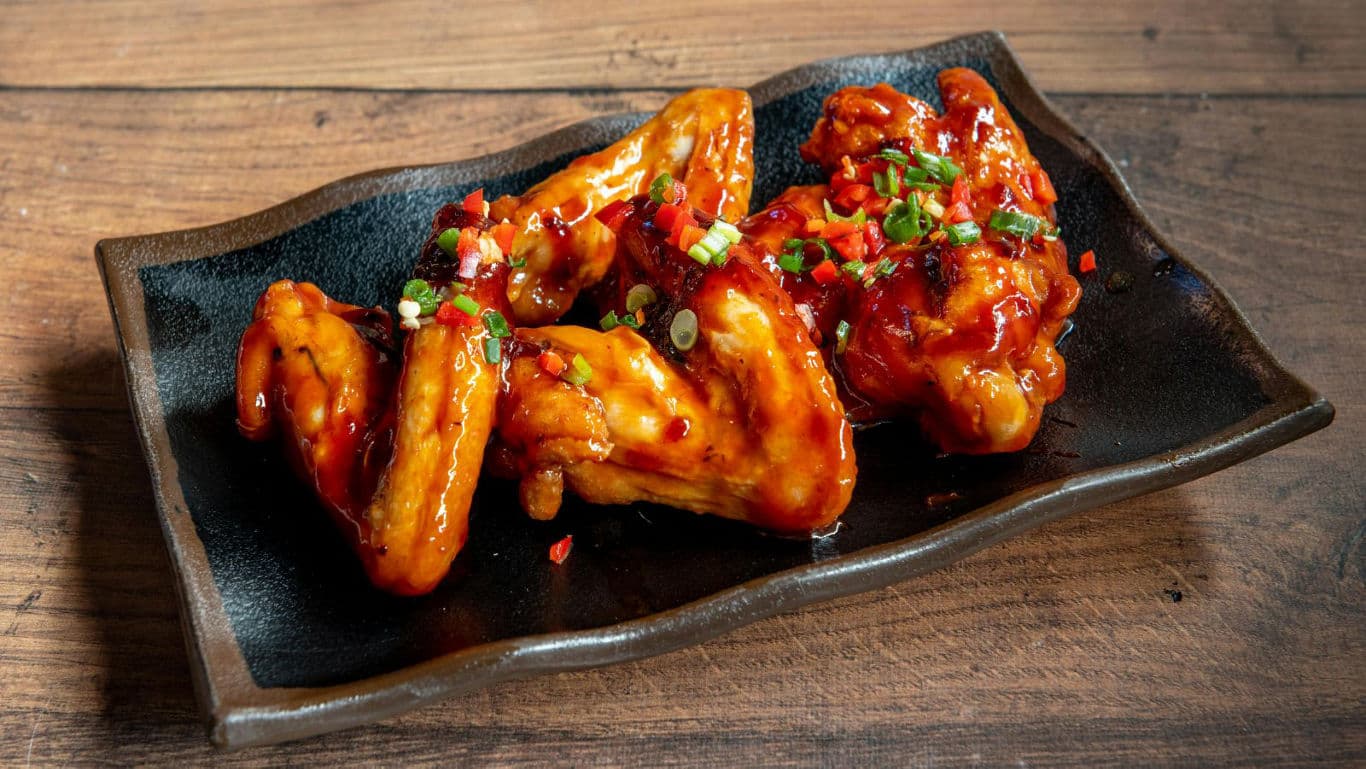 Spicy glazed chicken wings on platter